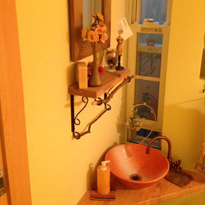 トイレの手洗い：手洗いボウルはもちろん、飾るものも吟味された飾り棚