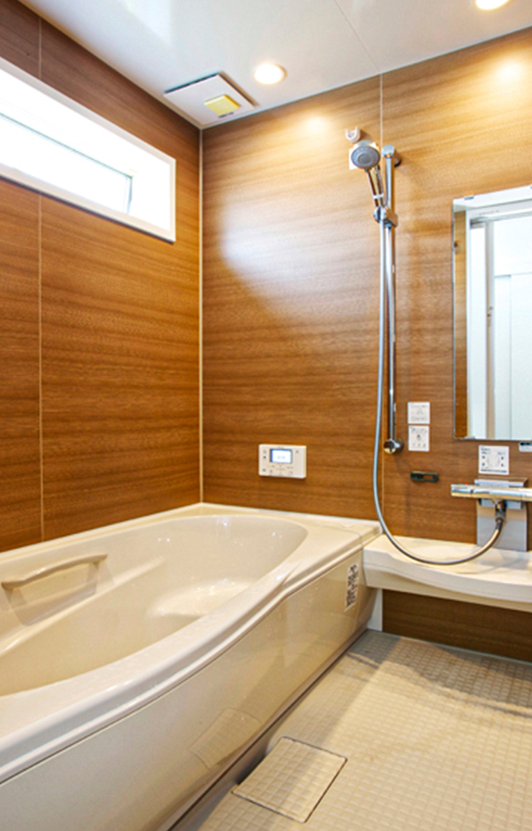 浴槽上の窓から差し込む優しい光と、木目を基調とした壁が、温かみのある空間を生み出します。