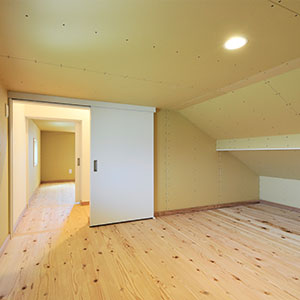 屋根裏収納。収納庫空間なので壁天井は下地材のまま使用。注文住宅ならではの仕様の選択。