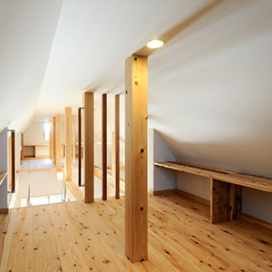 小屋裏収納の床は杉。格子の仕切で２階空間と一体化。吹き抜けから光も風も呼び込む。