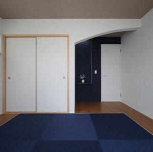 青い畳とアクセントクロス、Ｒ垂壁ですっきりとした印象の和室。