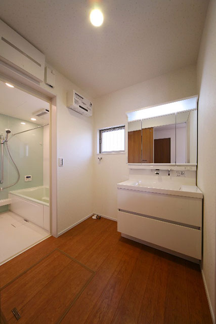 W900の洗面とさわやかなミントグリーンがアクセントの浴室。