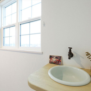 洗面：2階の小洗面は、アンティークカラーのカランと窓からの日差しが、ニュアンスのある空間を作り出します。