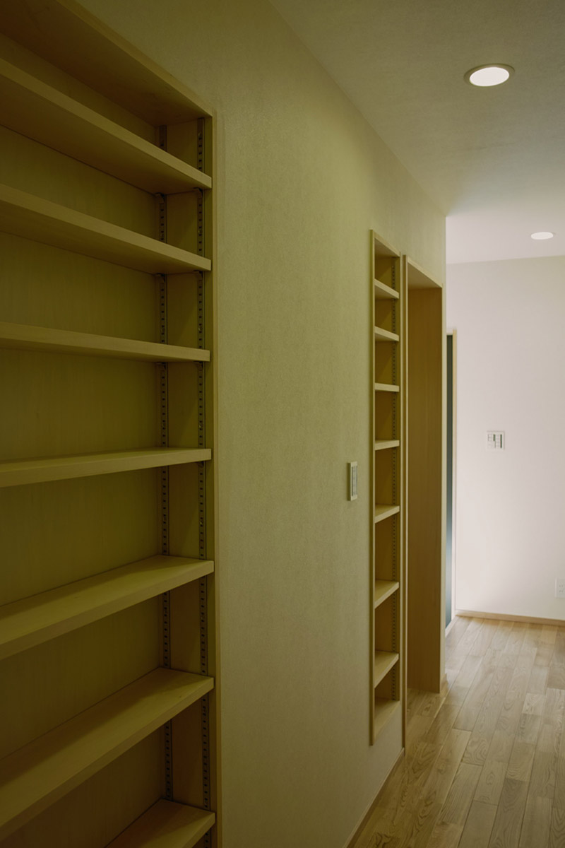 壁の厚さを利用した廊下にある本棚。わずかな隙間も無駄なく利用した計画。