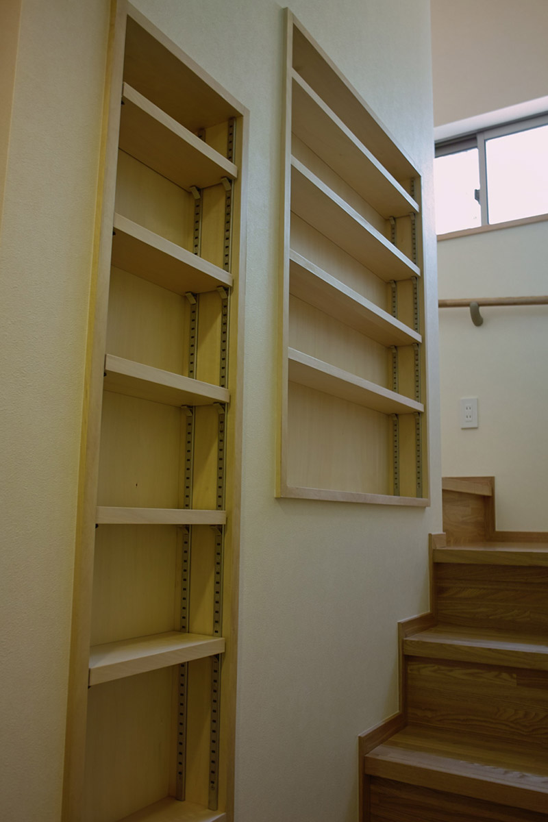 階段の壁の厚さを利用した本棚。階段を椅子として利用すれば、読書スペースに変わる。