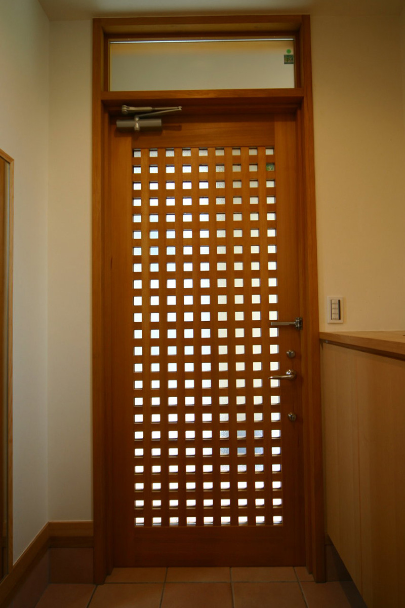 玄関：小さな格子の木製の玄関扉です。建具屋さんに制作してもらいました。