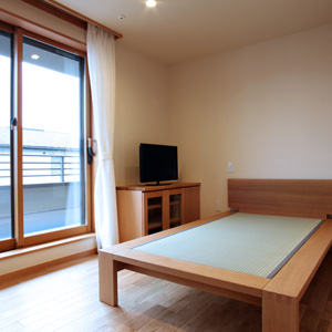 寝室：2階の寝室は広いバルコニーに面しています。日当たりがよく温かな部屋になります。天井と壁は月桃紙です。