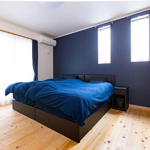 ブルーのアクセントクロスが印象的な寝室