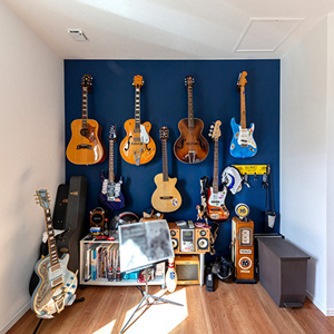 ダイニングの壁は一面だけデニム色にし、ギターを飾る収納にしました。スペースにゆとりを持たせて、ギター演奏のステージや、親族が集まったときに子どもが遊べるスペースとして活用しているそうです。