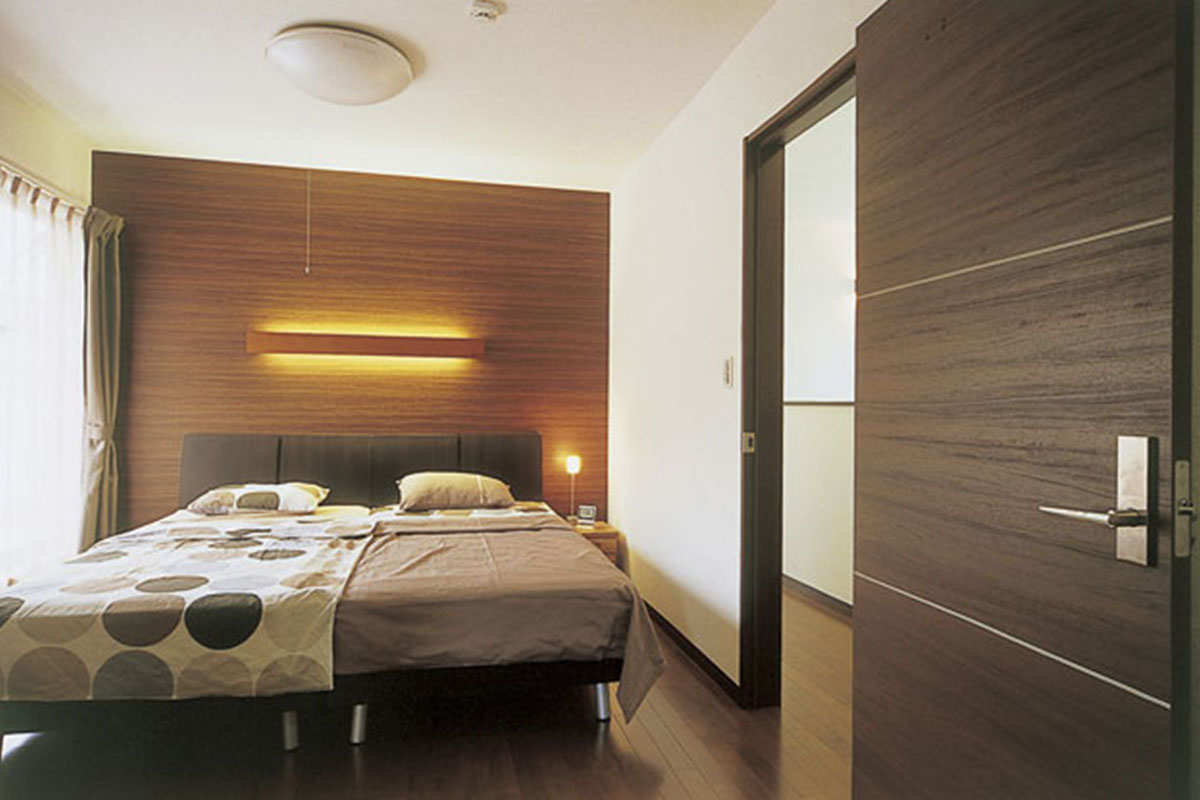 木調クロスとダークブラウンを基調としたインテリアで、寝室は高級感漂うホテルのよう