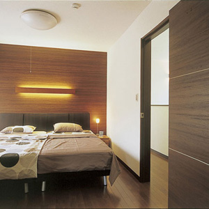 木調クロスとダークブラウンを基調としたインテリアで、寝室は高級感漂うホテルのよう