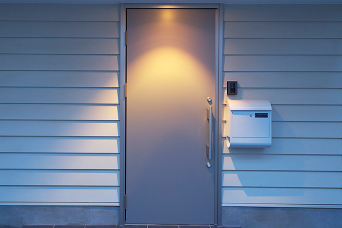 白いポストとスタイリッシュなステンレス扉がモダンな雰囲気を演出する玄関