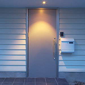 白いポストとスタイリッシュなステンレス扉がモダンな雰囲気を演出する玄関