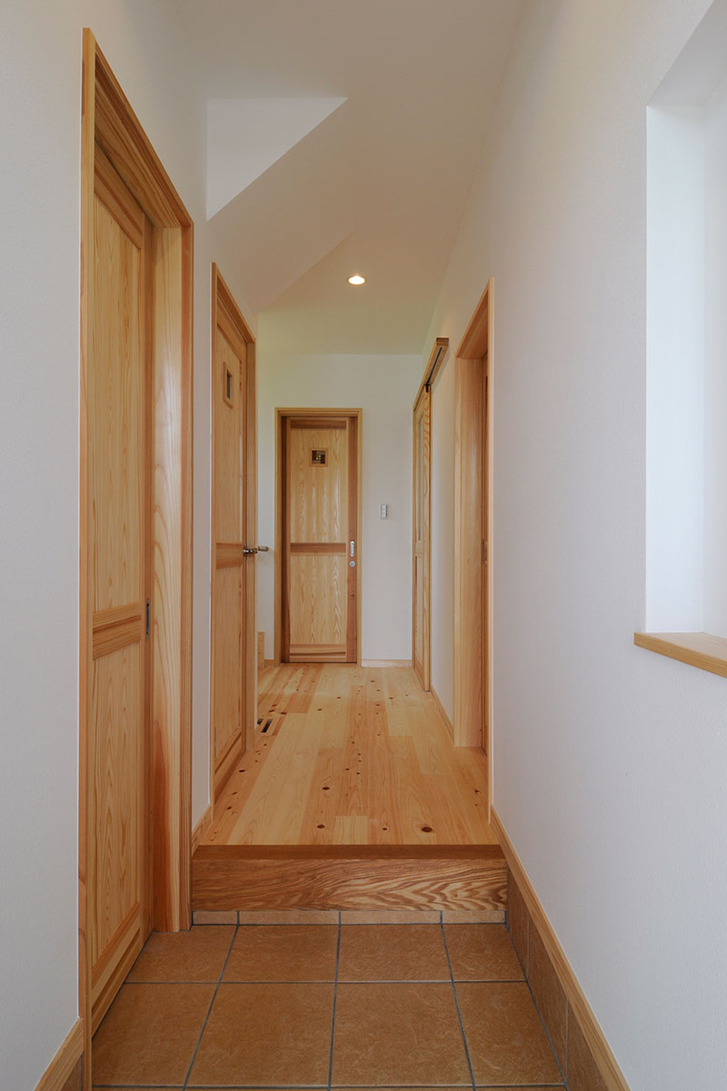 玄関ホールは檜の床、壁は紙クロス。手前左扉はシューズクローク