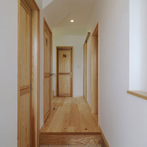 玄関ホールは檜の床、壁は紙クロス。手前左扉はシューズクローク