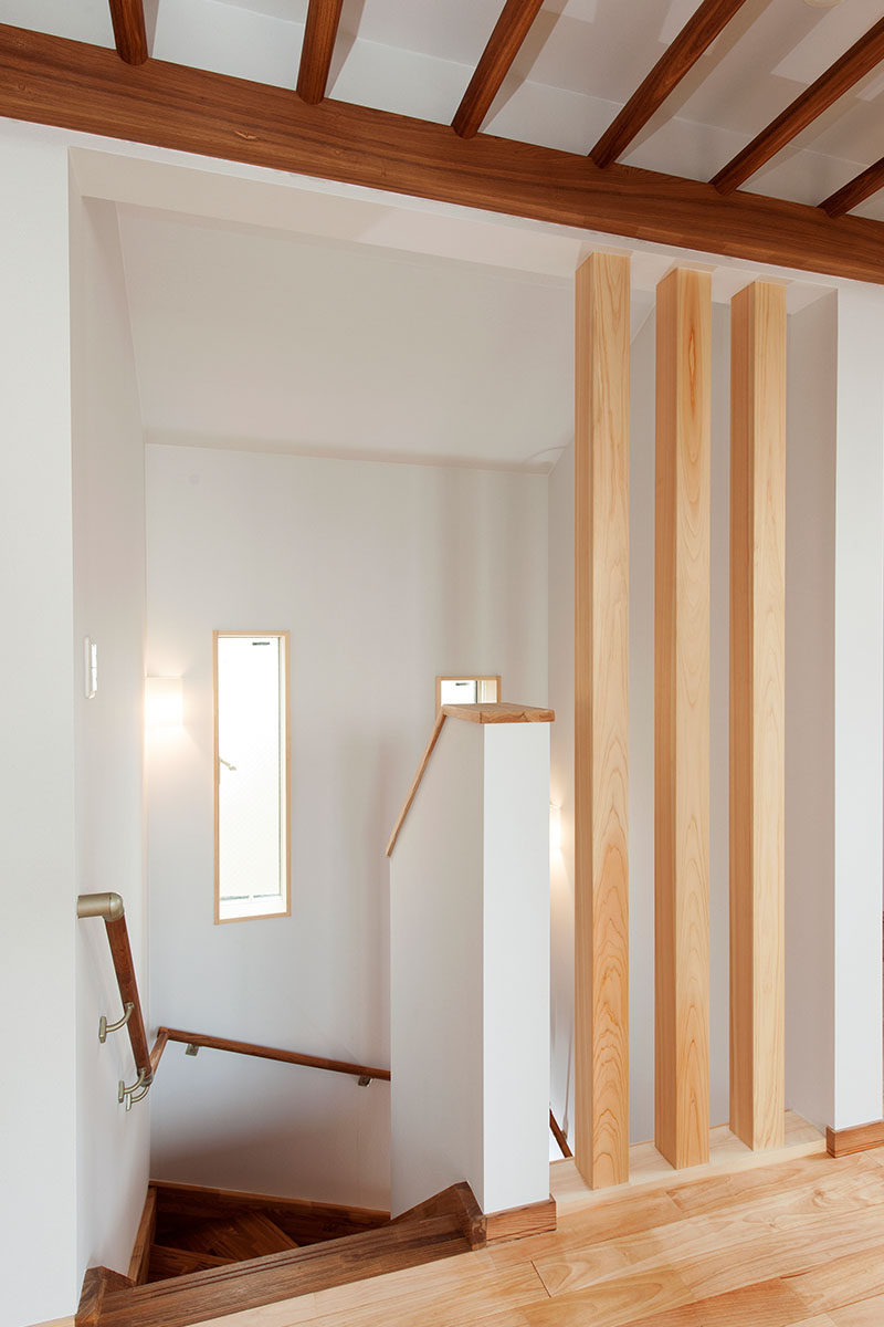 階段２階廊下部分を檜柱材で格子にし1、2階の空間をつなぐ　　縦長窓で光をとりこむ