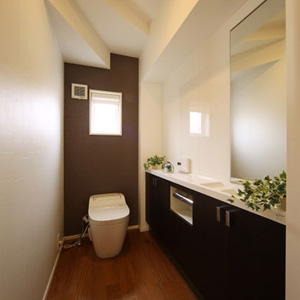 壁一面の収納があるトイレはパネルを張り清潔感を強調しました。