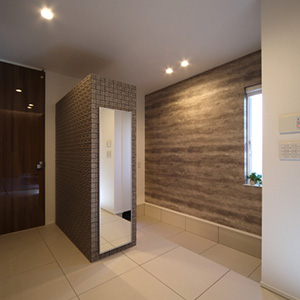 600角のタイル床とモザイクタイルを貼った収納が上質な雰囲気の玄関。