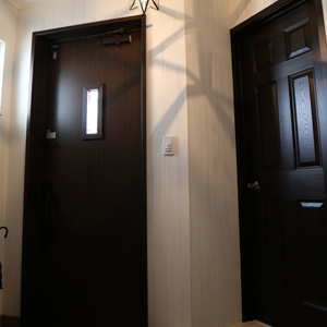 玄関：濃いブラウンのドアに、フレンチビンテージの星形ランプの陰影が美しくきらめきます。