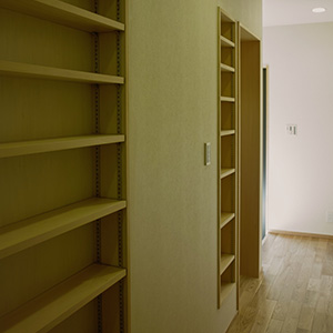 壁の厚さを利用した廊下にある本棚。わずかな隙間も無駄なく利用した計画。