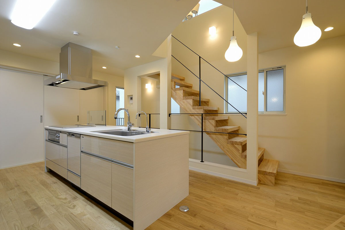 アイランドタイプのキッチン奥にあるスケルトン階段が空間に広がりをもたらします。