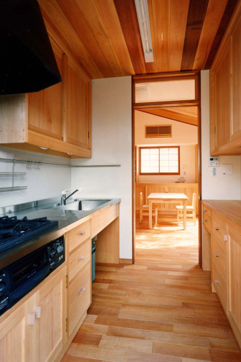 台所：ベニ松で作り付けにした流し台と食器棚。入れる食器などに合わせて引き出しや収納のサイズを決めています。