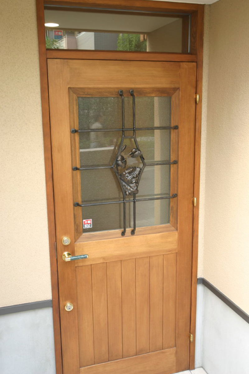 玄関扉：特注の木製玄関戸です。面格子は鍛鉄工芸家に依頼して制作してもらっています。