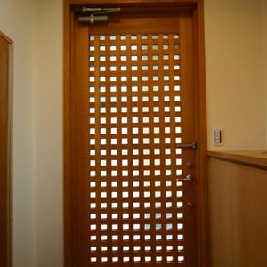 玄関：小さな格子の木製の玄関扉です。建具屋さんに制作してもらいました。