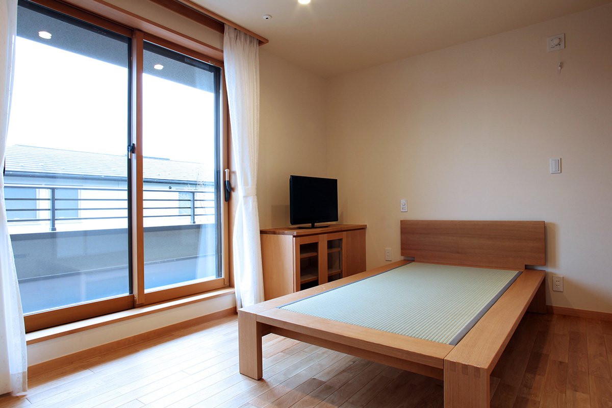 寝室：2階の寝室は広いバルコニーに面しています。日当たりがよく温かな部屋になります。天井と壁は月桃紙です。