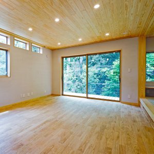 リビングからは雑木林の緑だけが見えます。床はクリの無垢フローリング、天井はくりこま杉です。低温水床暖房で冬も暖かく暮らすことができます。