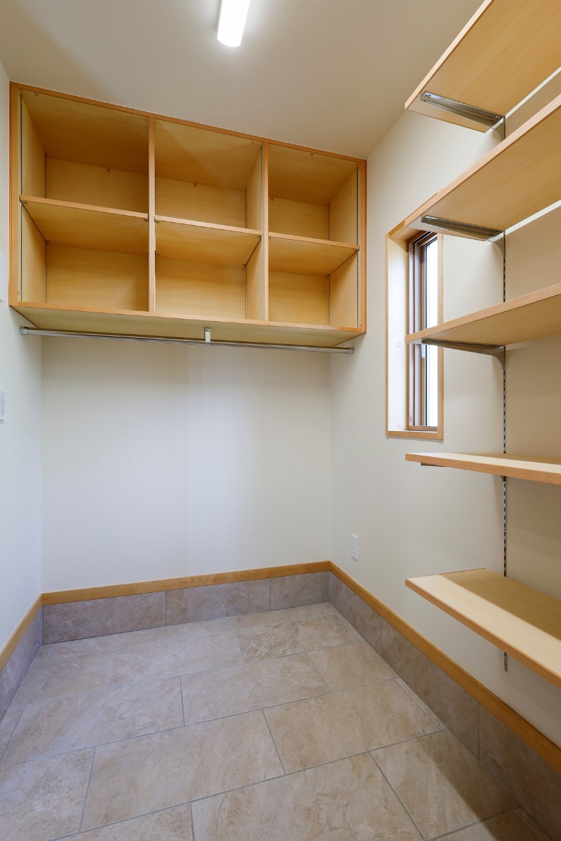 シューズクロークのおおきな収納です。上部に作り付けのタナを、下には多目的に使えるステンレスパイプをつけています。 シューズクロークのおおきな収納です。上部に作り付けのタナを、下には多目的に使えるステンレスパイプをつけています。