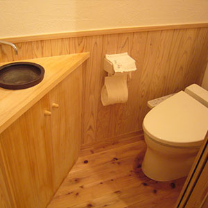 トイレはお水がかかる部分を杉の腰板でガードしながら漆喰の壁で。陶器の手洗いが使い易いとお施主様の声。