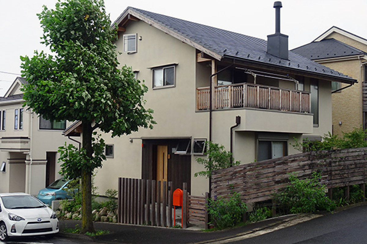 街路樹が立ち並ぶ住宅街の角地に落ち着いた佇まいのお宅、深い軒を持つバルコニーと薪ストーブの煙突がシンボルです