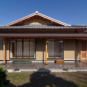 佇まいを引き締める軒出の深い入母屋の瓦屋根と銅板葺き庇屋根