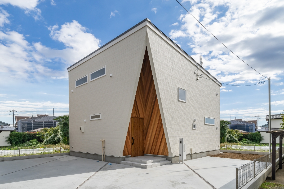 印象的な三角形のエントランスが住まいの個性を引き立てる、シンプルモダンな注文住宅の外観。