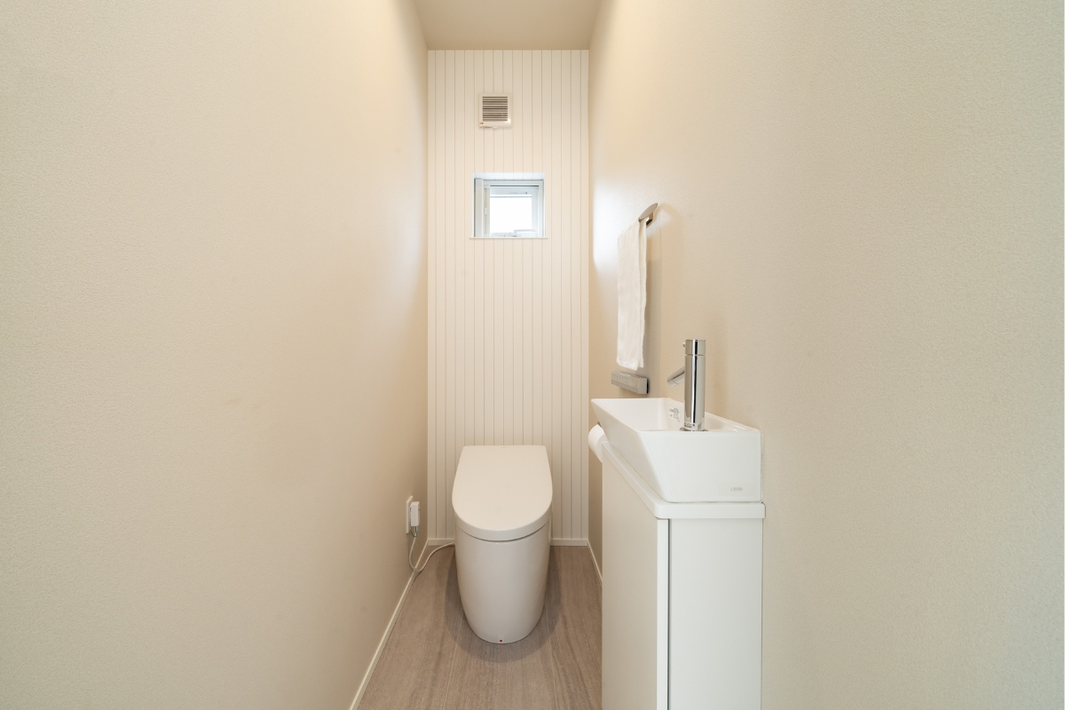 角型手洗いカウンターと採光窓を備えた、清潔感あるトイレ空間 角型手洗いカウンターと採光窓を備えた、清潔感あるトイレ空間
