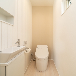 タンクレス風トイレと横長手洗いカウンターを備えた、すっきり縦長のトイレ空間