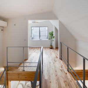 吹き抜けを見下ろす2階ホール、スチール手すりと勾配天井が魅せる開放的な空間 吹き抜けを見下ろす2階ホール、スチール手すりと勾配天井が魅せる開放的な空間