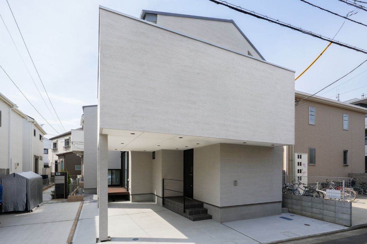 白い塗り壁と大胆な庇の張り出しが目を引く、彫刻的な外観デザイン