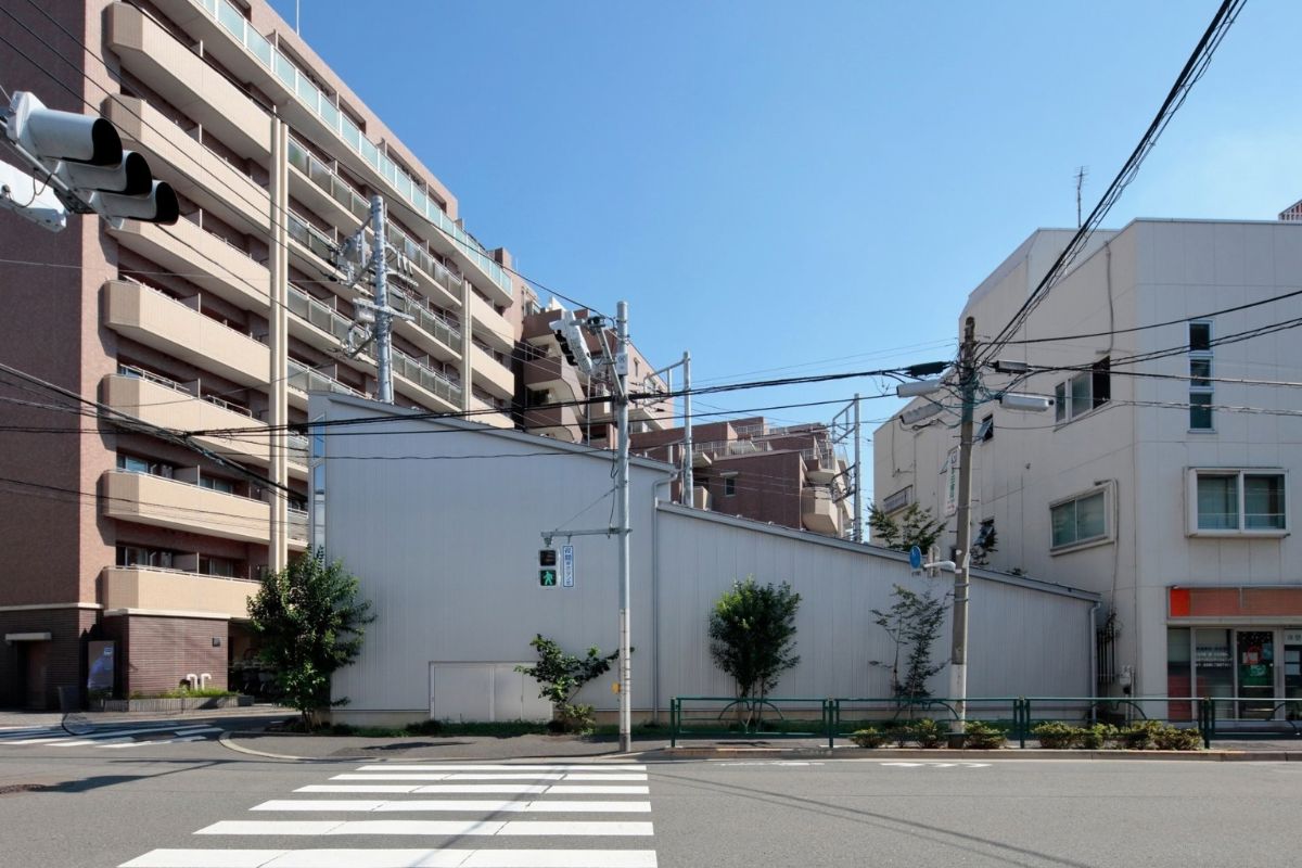 交差点に面した外観。長く伸びる壁が街並みに連続する