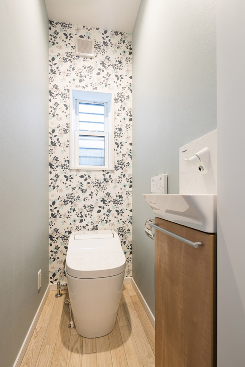 トイレは、壁の一面に植物柄のアクセントクロスを使用しオシャレな空間に。