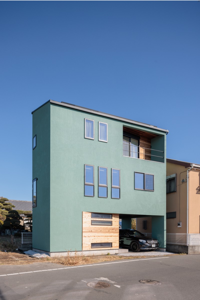 13坪の敷地は、横細長で、建物の奥行きは1.5間ほどしかとれない究極の狭小住宅。ピーコックグリーンとレッドシダーの外壁が湘南の空に映える外観。