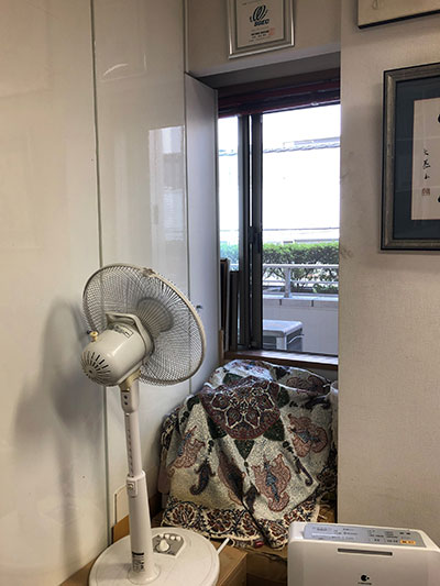 写真:高さのある窓の上を扇風機の角度で排気、下から給気(アトリエ4A事務所)