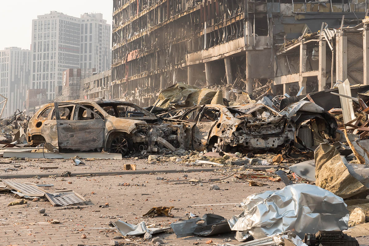 2022 Russian invasion of Ukraine war torn city destroyed car burn out. War crime Russia bombed building damage cars destruction city ruins building insurance car. Terror attack bomb damage war ruins