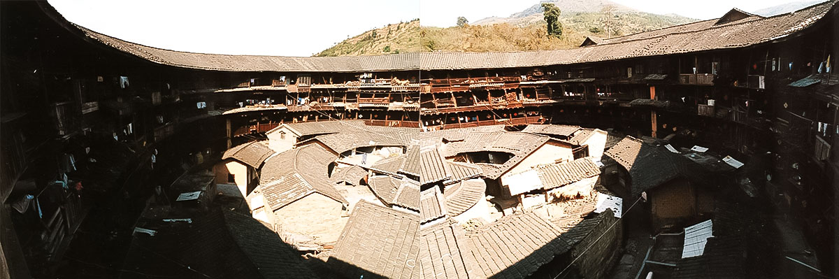 ＜写真：防御集落の中国永定「客家」土楼、中の屋根は寺や豚舎（撮影：天野 彰）＞