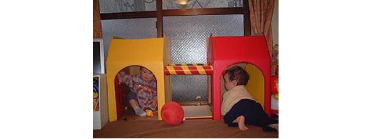 室内のキッズスペースでトンネル型遊具を使って遊ぶ子どもたちの様子