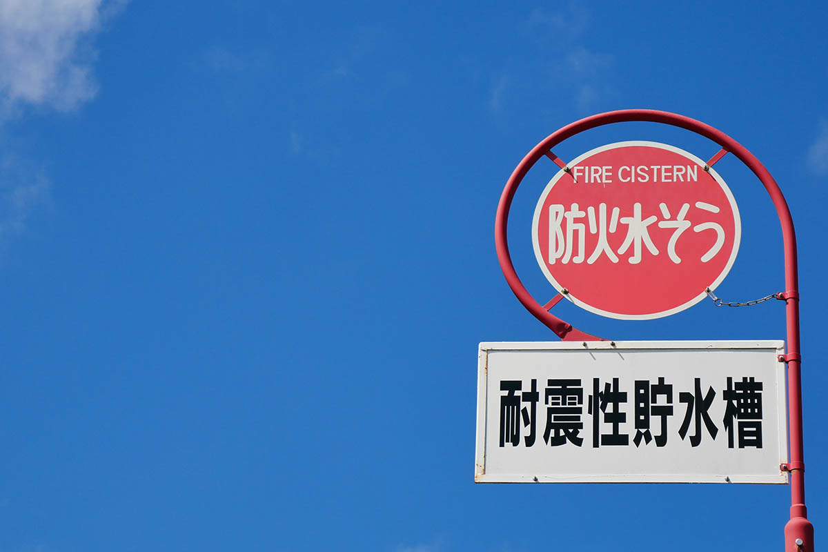 青空と白い雲と防火水槽の標識