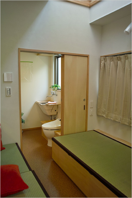 引き戸を開けると畳ベッドからそのまま足を降ろしてベンチ式トイレへ（写真：天野彰）