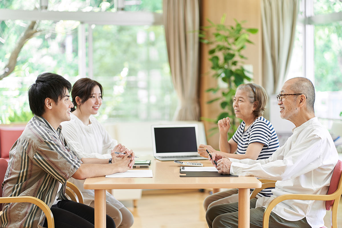 笑顔で会話する若夫婦と老夫婦