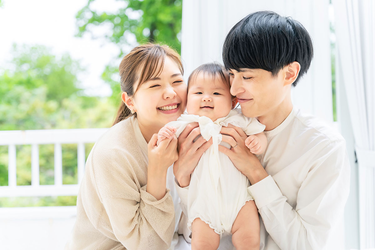 笑顔の赤ちゃんと両親 子育てイメージ